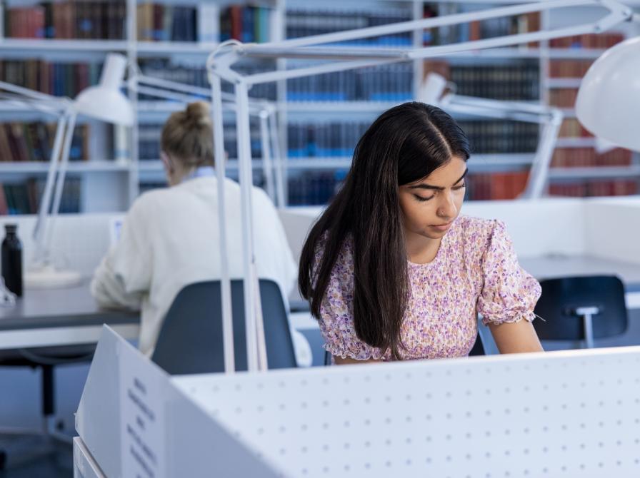 Ung kvinde arbejder på studieplads